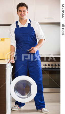 Happy specialist with tooling near washing machine Happy specialist with tooling near washing machine 19956739