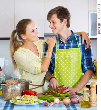 man and woman standing near table in domestic kitchen 19957371