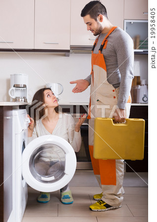 Housewife showing broken washing machine 19958405