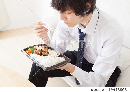 コンビニ弁当を食べる若いビジネスマン 19958868