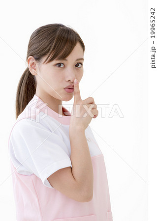 人差し指を口元にあてる女性の写真素材