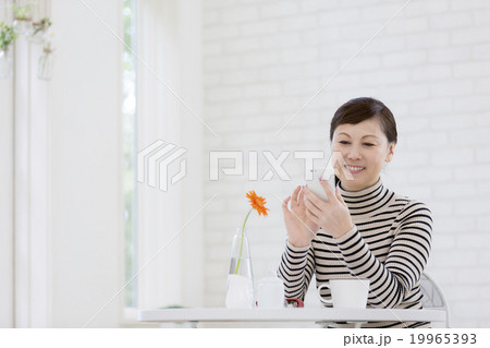 スマートフォンを持つ40代の女性 19965393