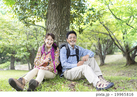 木の下に座る夫婦の写真素材