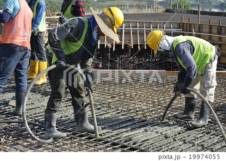 Construction Workers Using Concrete Vibrator 19974055