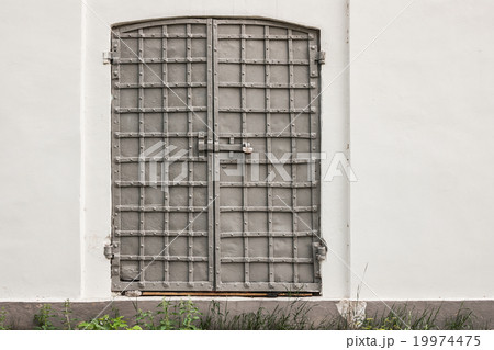 old iron shod gate of church in a white wall 19974475