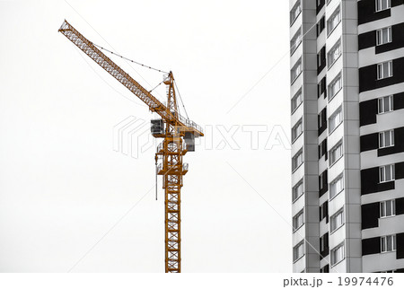 yellow construction crane and high-rise building 19974476
