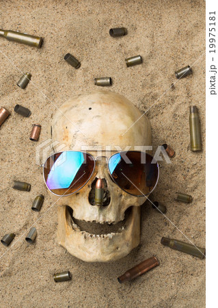 skull lying in the sand, scattered rifle and skull lying in the sand, scattered rifle and 19975181
