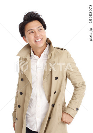 トレンチコートを着た若い男性の写真素材