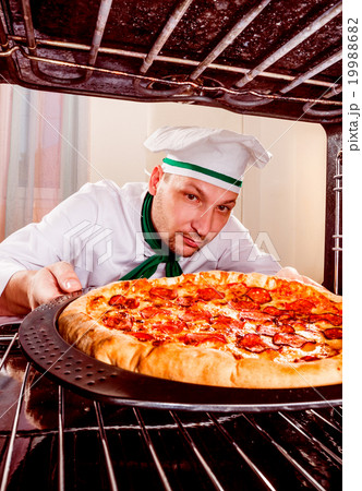 Chef cooking pizza in the oven. 19988682