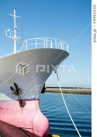 港に停泊する貨物船の先端の写真素材