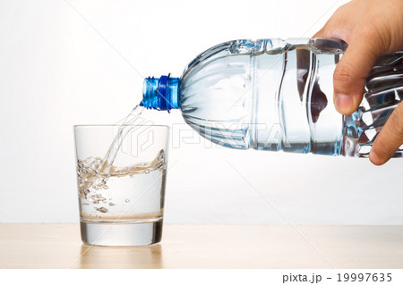 Hand pouring refreshing mineral water from bottle 19997635