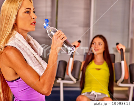 Girls drinking water in sport gym.  19998312