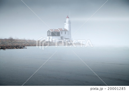 lighthouse in the fog is on the pier into the sea. mystical land lighthouse in the fog is on the pier into the sea. mystical land 20001285