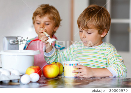 Two little kid boys baking apple cake indoors 20006979