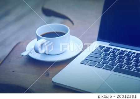 coffee in a white cup on a table with a computer coffee in a white cup on a table with a computer 20012381