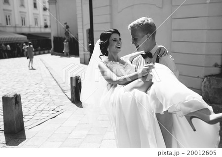 groom carries bride in his arms groom carries bride in his arms 20012605