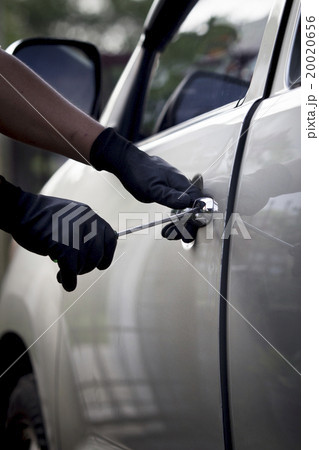 Car thief using a tool to break into a car. Car thief using a tool to break into a car. 20020656