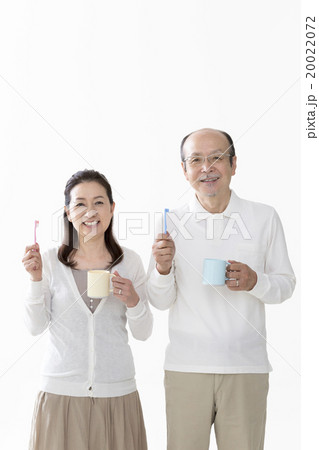 歯ブラシとコップを持つシニア夫婦 歯ブラシとコップを持つシニア夫婦 20022072