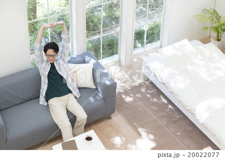 背伸びをする20代の男性 20022077