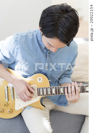 エレキギターを弾く代の男性の写真素材