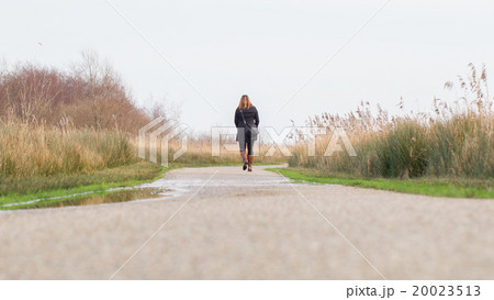 Young woman walking in a dutch landscape Young woman walking in a dutch landscape 20023513