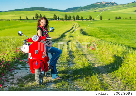Young woman traveling by a scooter Young woman traveling by a scooter 20028098