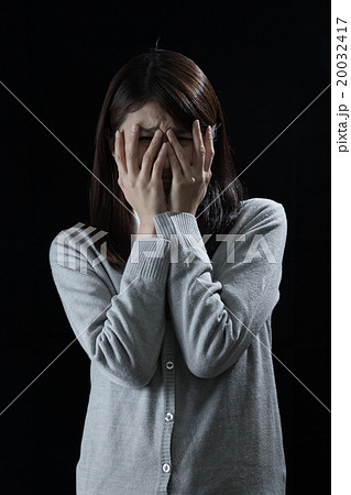 ショックを受ける女性 泣く 顔を覆うの写真素材