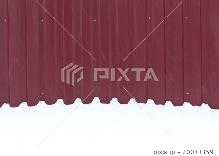 Red metal fence in snow. 20033359
