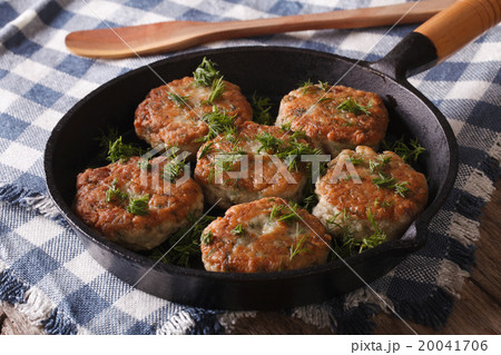fishcakes with herbs close-up in a pan. Horizontal 20041706