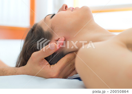Therapist massaging the neck of woman 20050864