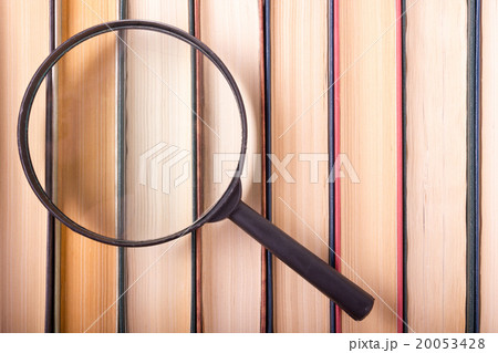 Stack of books with magnifying glass. Search 20053428