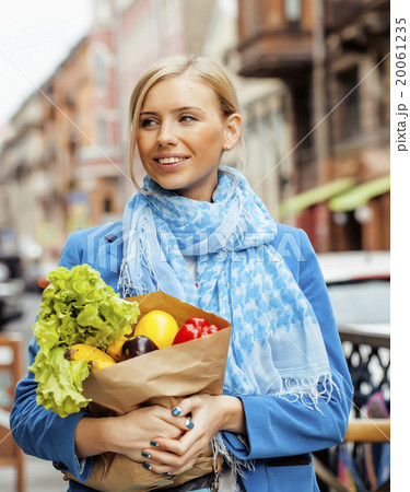 young pretty blond woman with food in bag walking 20061235