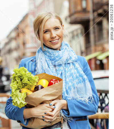 young pretty blond woman with food in bag walking 20061236