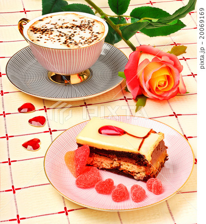 Cap of coffee, a rose and a cake on the tablecloth Cap of coffee, a rose and a cake on the tablecloth 20069169