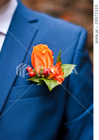 boutonniere of orange roses in the pocket of his 20072320