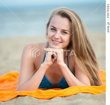 Young lady sunbathing on a beach. Beautiful woman 20076981