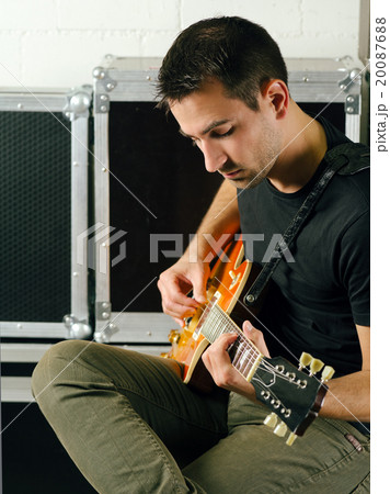 Man playing his electric guitar Man playing his electric guitar 20087688