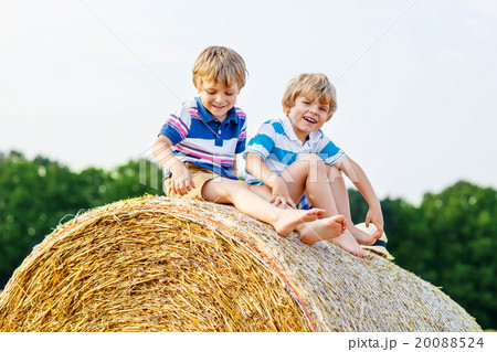 Two little children and friends with hay stack or 20088524