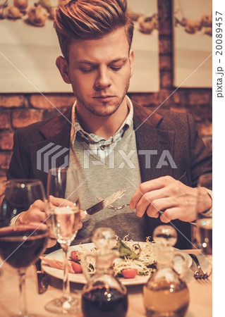 Stylish wealthy man eating at restaurant. 20089457
