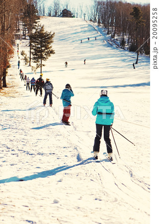Skiers going uphill on ski lift. Skiers going uphill on ski lift. 20095258