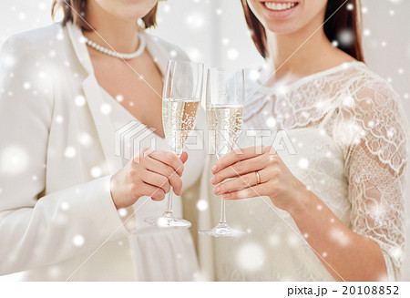close up of lesbian couple with champagne glasses 20108852