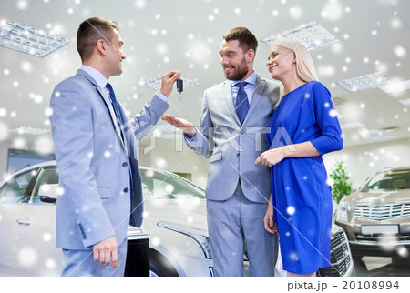 happy couple with car dealer in auto show or salon 20108994