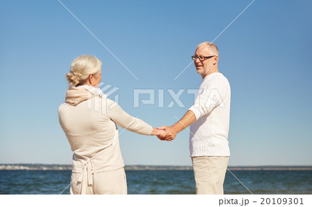 happy senior couple holding hands summer beach 20109301