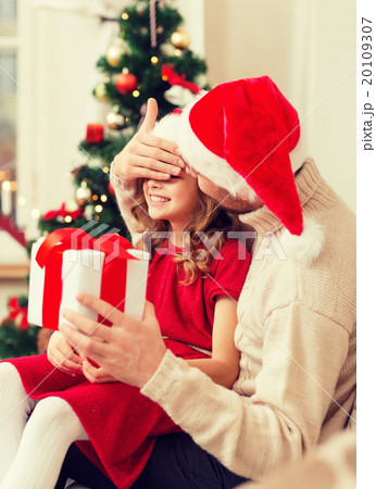 smiling father surprises daughter with gift box 20109307