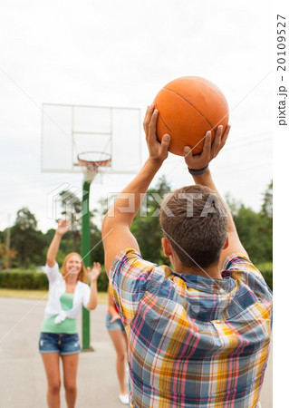group of happy teenagers playing basketball 20109527