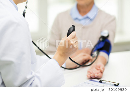doctor with tonometer and senior woman at hospital 20109920