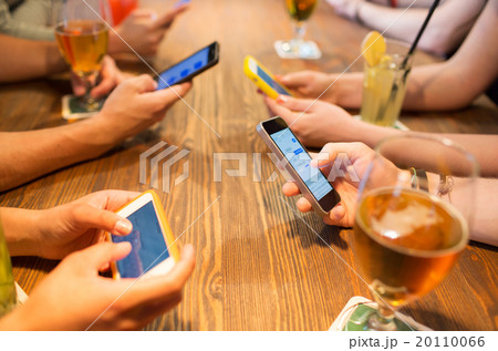 close up of hands with smartphones at restaurant 20110066