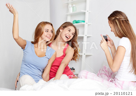 teen girls with smartphone taking picture at home 20110121