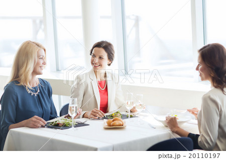 happy women eating and talking at restaurant 20110197