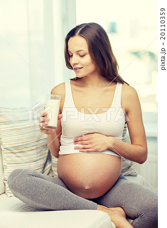 happy pregnant woman drinking milk at home 20110359
